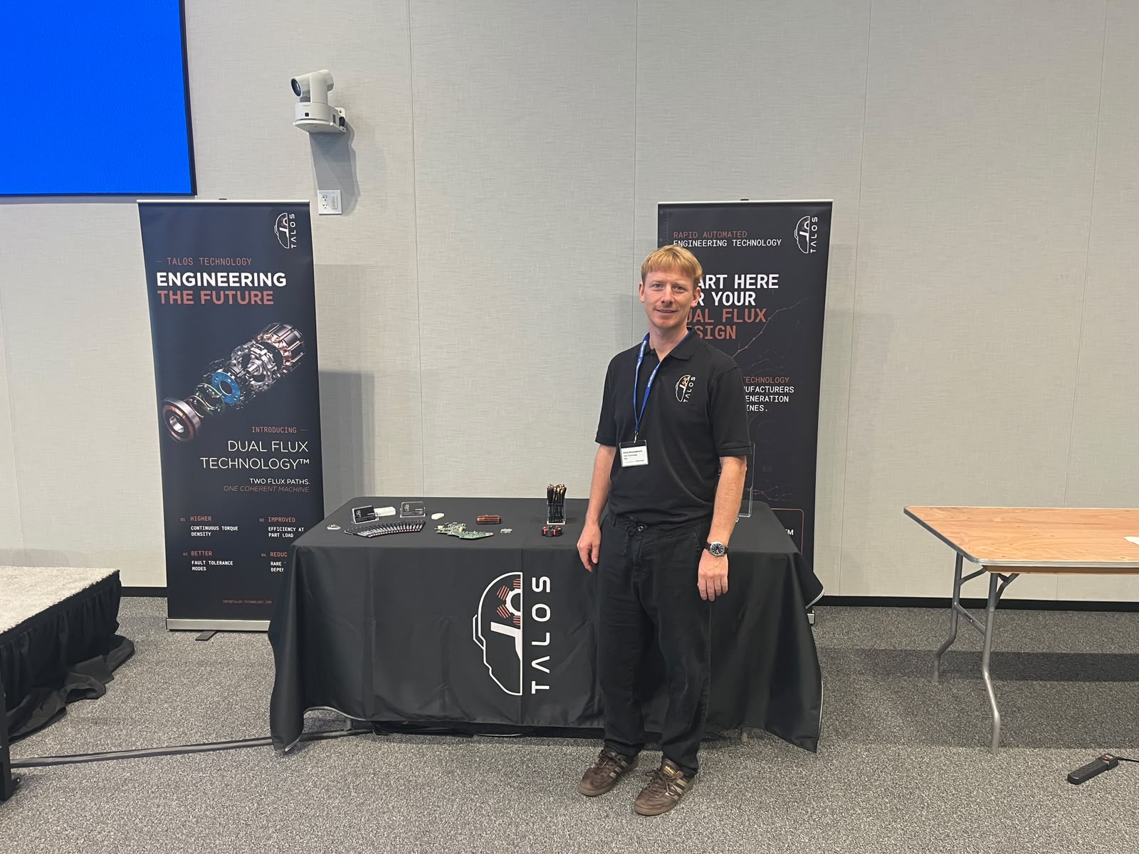 A Talos Technology team member at the Talos stand with Dual Flux Technology banners at the Ford supplier event